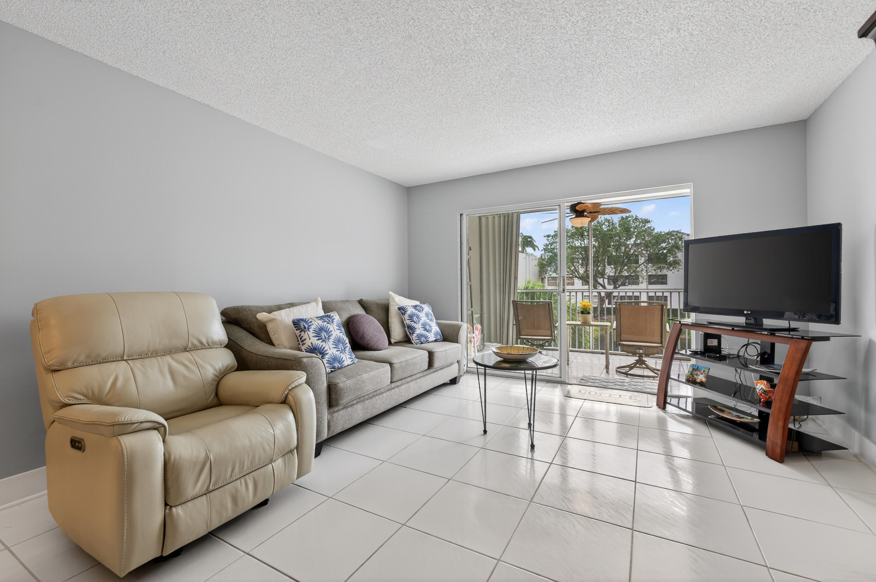 7142 South Devon Drive, Unit 210 Tamarac, FL 33321 - Photo 11 of 36 a living room with furniture and a flat screen tv