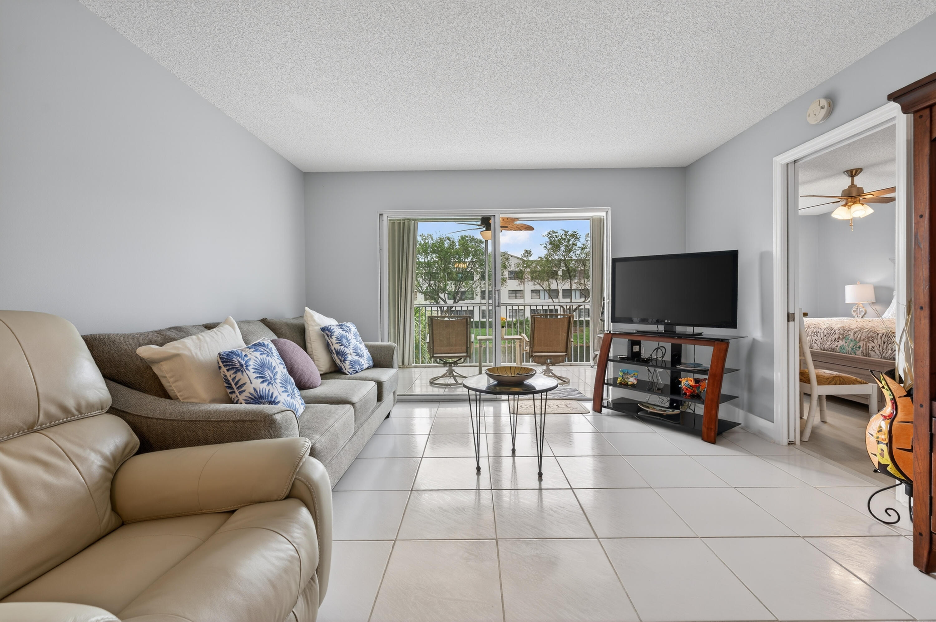 7142 South Devon Drive, Unit 210 Tamarac, FL 33321 - Photo 13 of 36 a living room with furniture and a flat screen tv