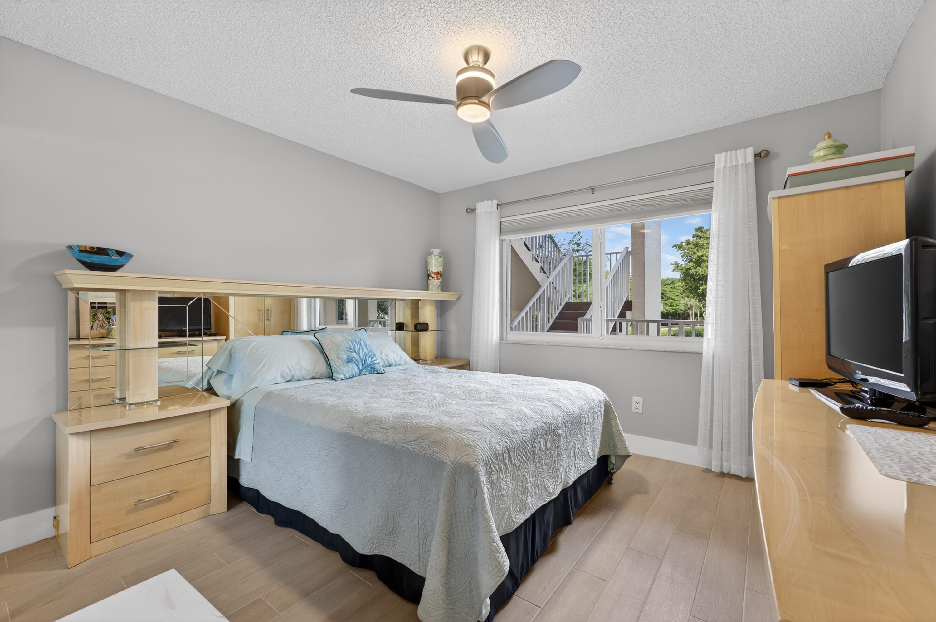 7142 South Devon Drive, Unit 210 Tamarac, FL 33321 - Photo 15 of 36 a bedroom with a large bed and a flat tv screen on dresser