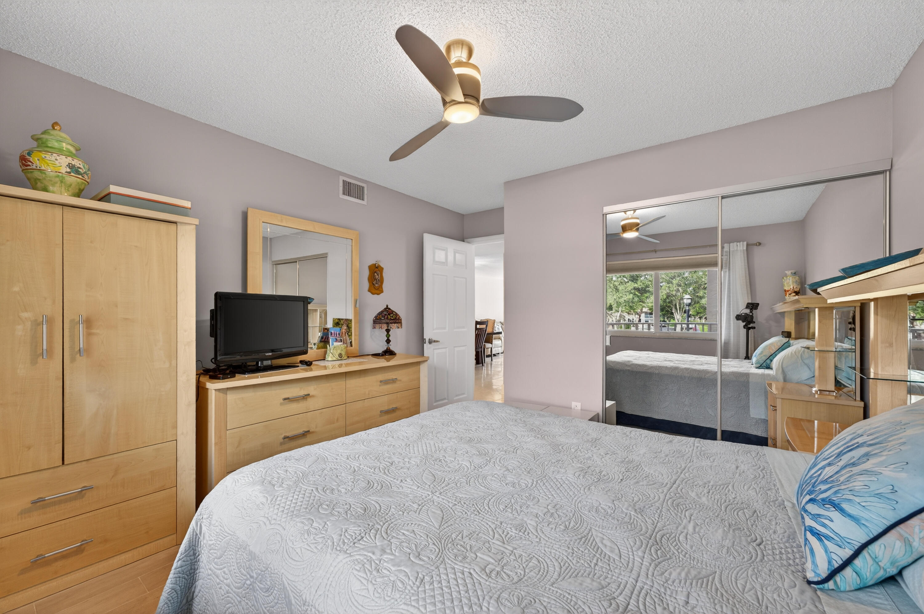 7142 South Devon Drive, Unit 210 Tamarac, FL 33321 - Photo 16 of 36 a bedroom with a large bed and a flat screen tv