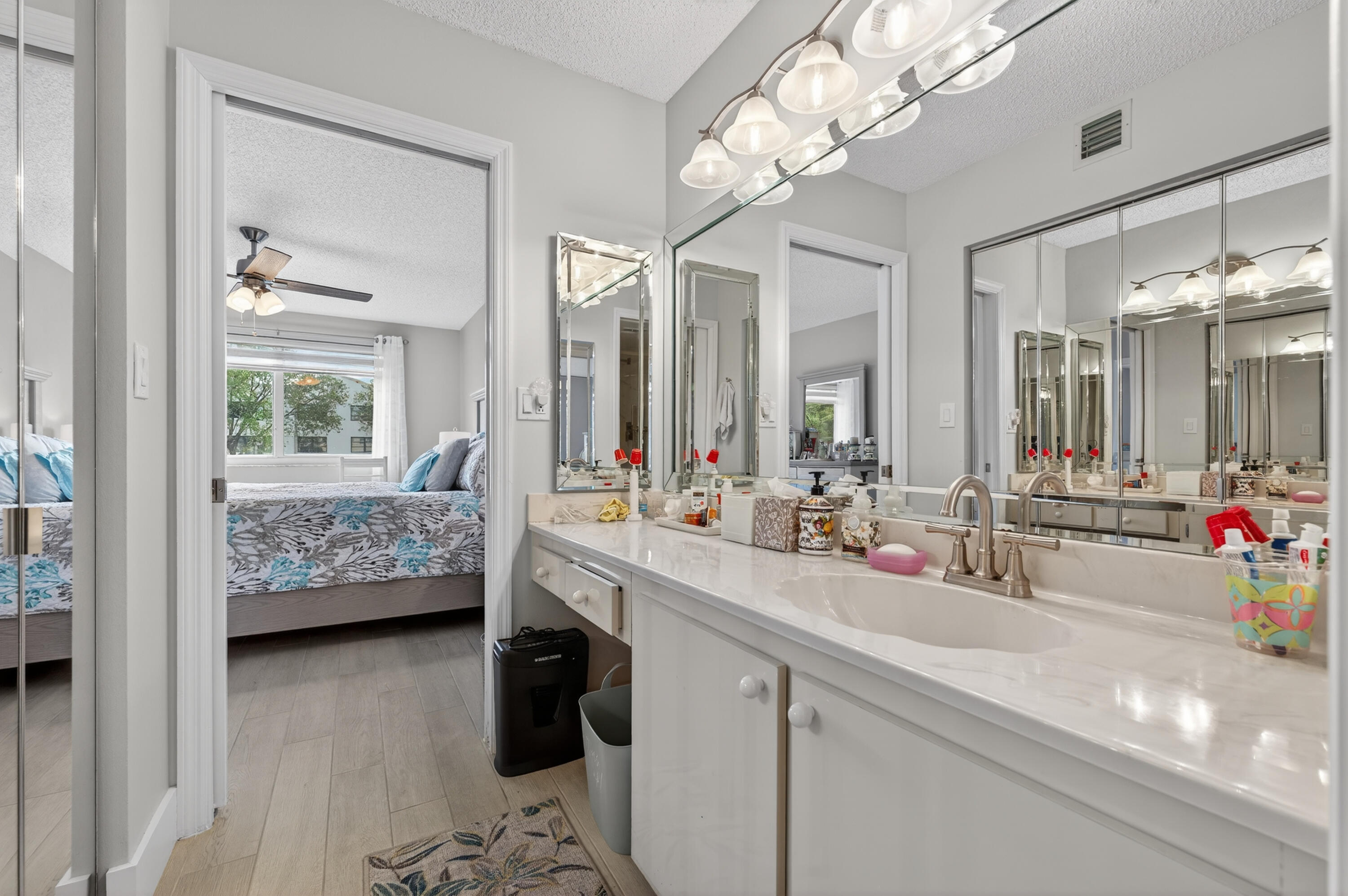 7142 South Devon Drive, Unit 210 Tamarac, FL 33321 - Photo 27 of 36 a bathroom with a double vanity sink mirror and chandelier