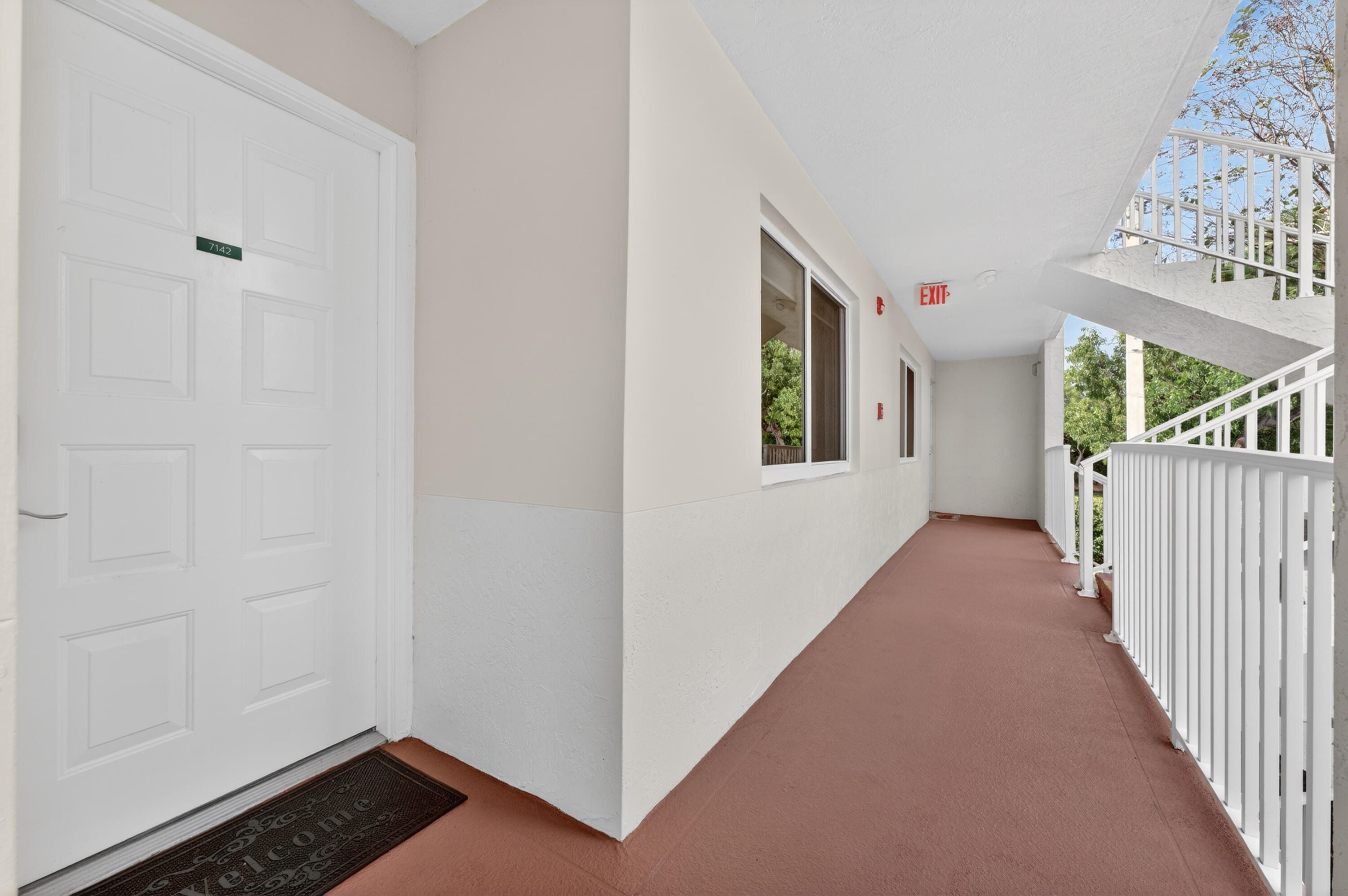 7142 South Devon Drive, Unit 210 Tamarac, FL 33321 - Photo 3 of 36 a view of a hallway with windows and stairs
