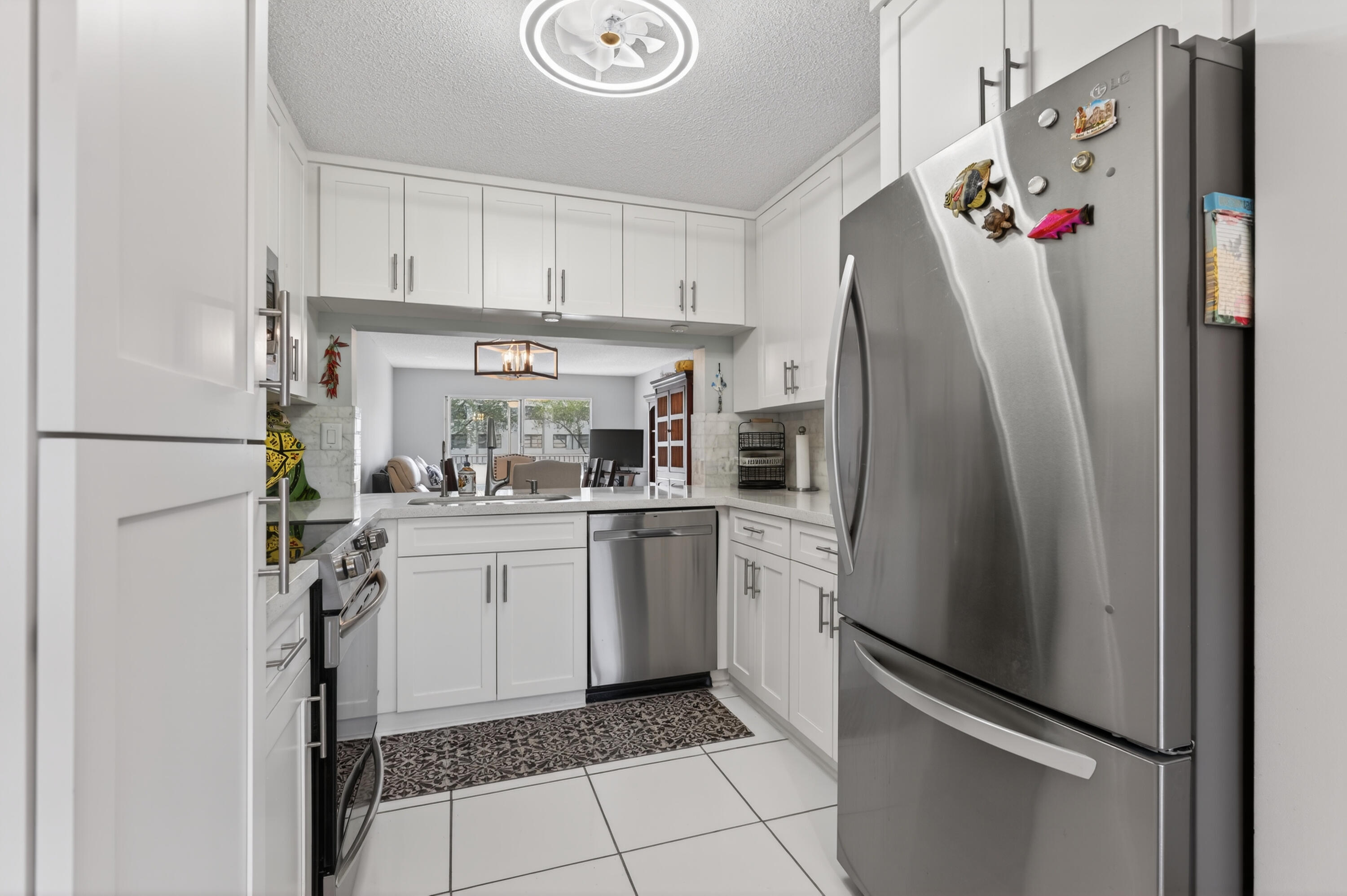 7142 South Devon Drive, Unit 210 Tamarac, FL 33321 - Photo 6 of 36 a kitchen with a refrigerator and white cabinets