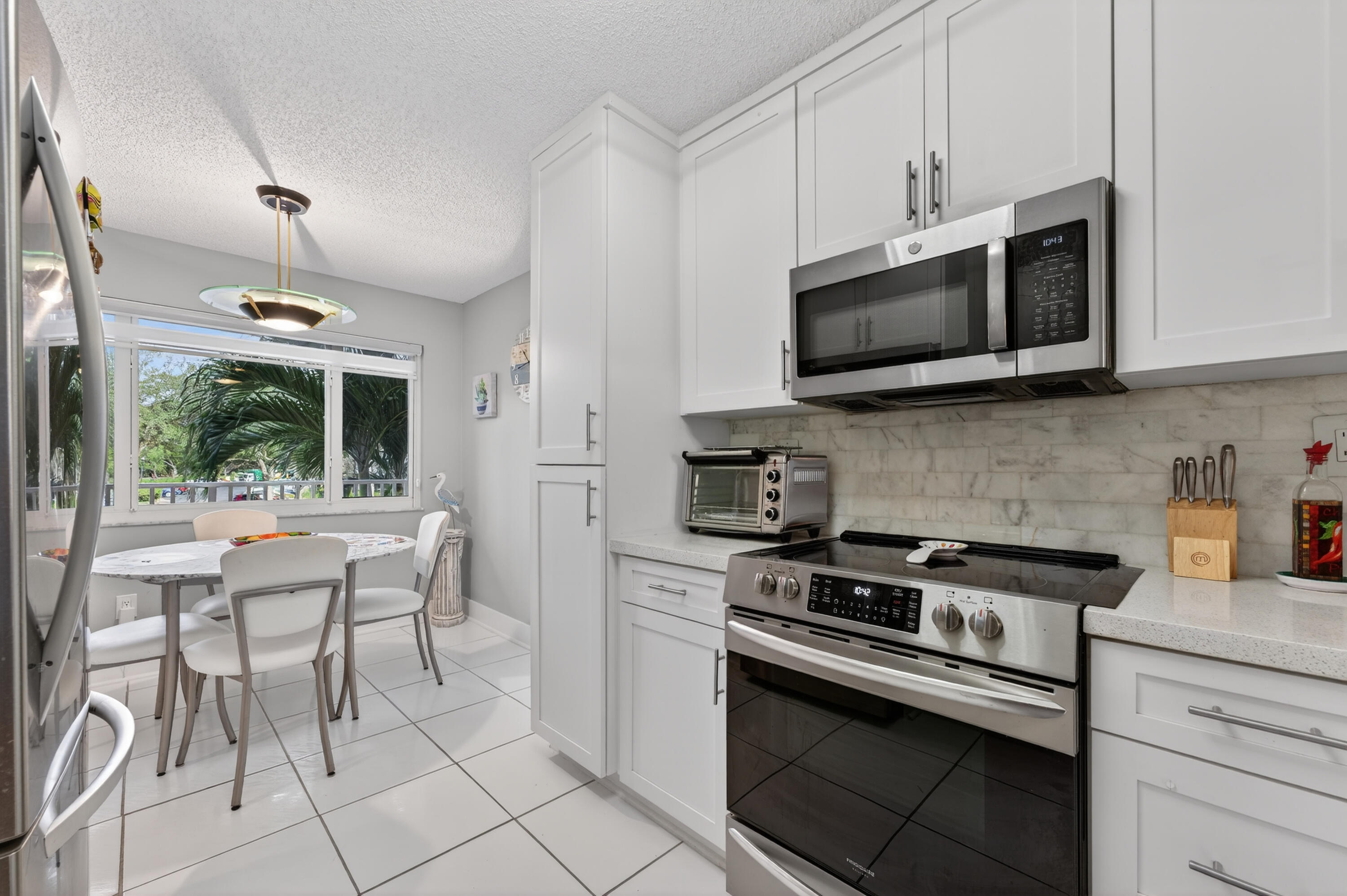 7142 South Devon Drive, Unit 210 Tamarac, FL 33321 - Photo 8 of 36 a kitchen with stainless steel appliances a stove a sink and a microwave