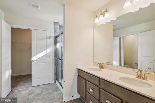 a bathroom with a double vanity sink mirror and shower