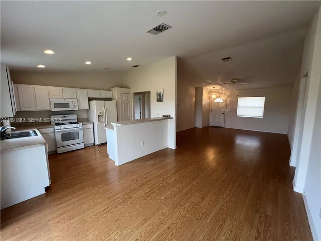a view of a kitchen with furniture and wooden floor
