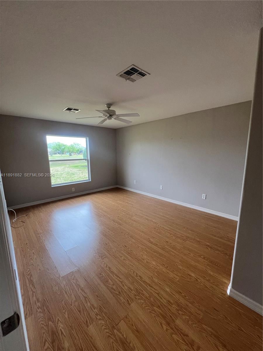 1679 Southwest 156th Lane Ocala, FL 34473 - Photo 8 of 16 an empty room with wooden floor and windows