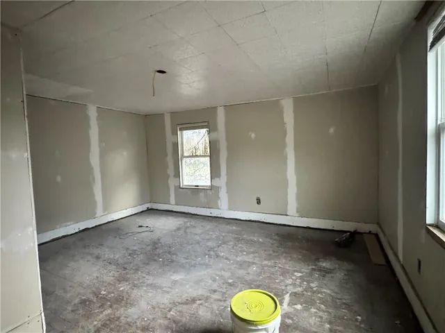 an empty room with windows and cabinet