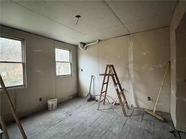 a view of a room with wooden floor and windows