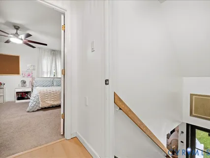 a view of a livingroom with wooden floor and a ceiling fan