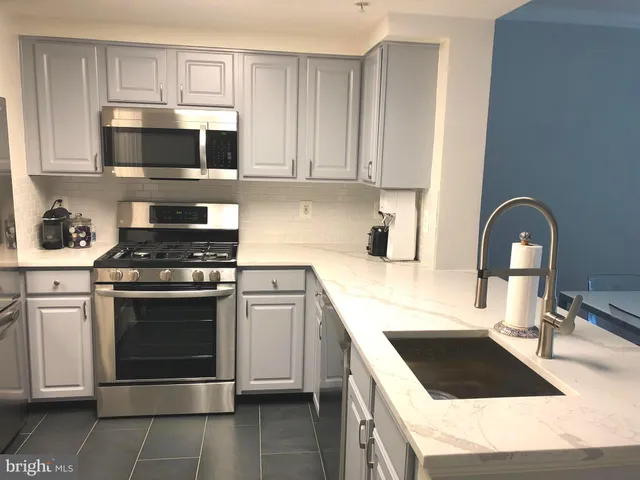 a kitchen with stainless steel appliances a stove a microwave and cabinets