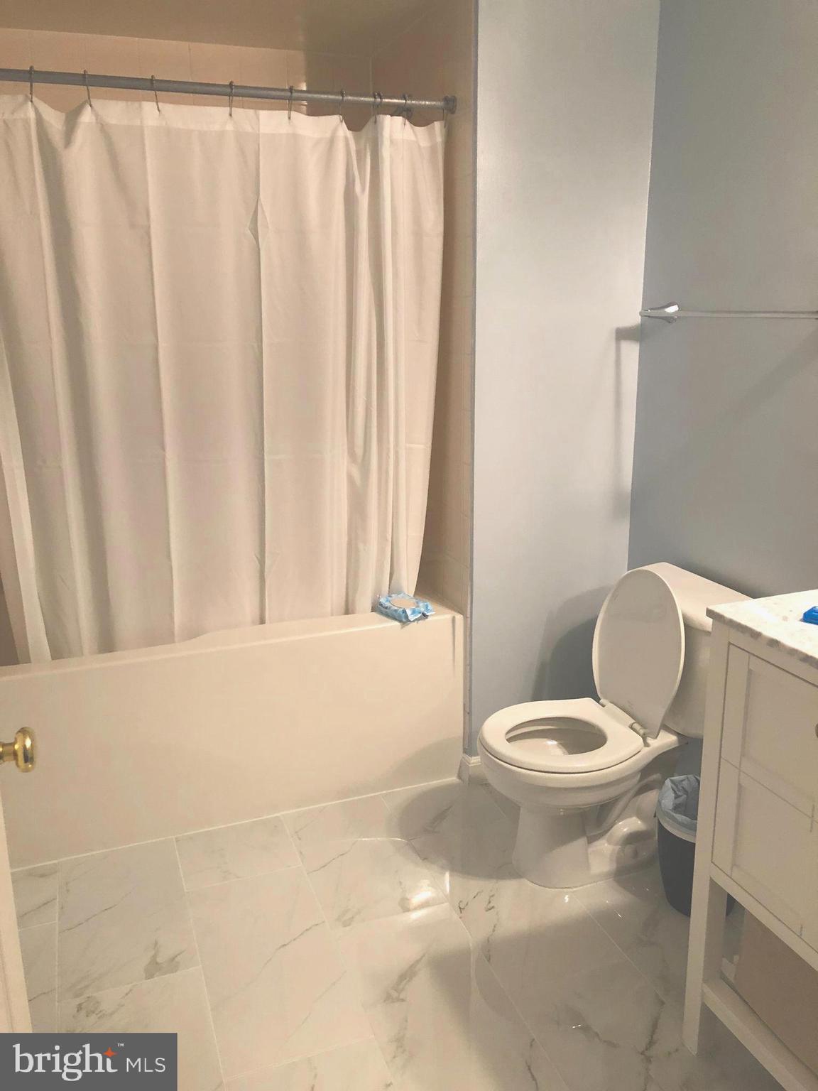 3830 9th Street North, Unit 607E Arlington, VA 22203 - Photo 9 of 17 a bathroom with a toilet and a shower curtain