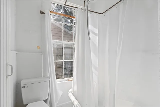 a living room with furniture a chandelier and a potted plant