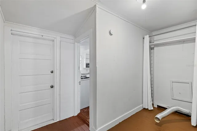 a kitchen with a stove a sink and wooden floor