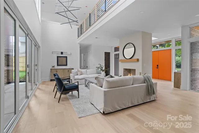 a living room with furniture a fireplace and a chandelier