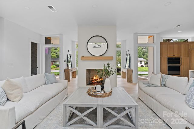 a living room with furniture a fireplace and a large window