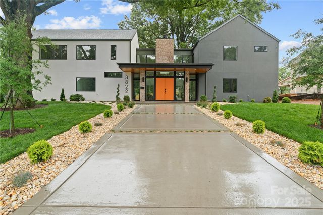 a front view of a house with a yard and potted plants