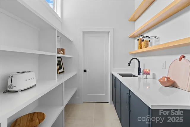 a kitchen with stainless steel appliances a sink a stove and white cabinets