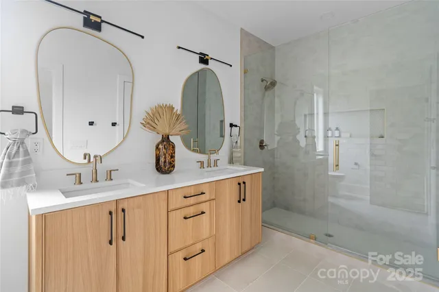 a bathroom with a double vanity sink mirror and shower