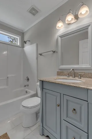 an empty room with a chandelier fan and windows