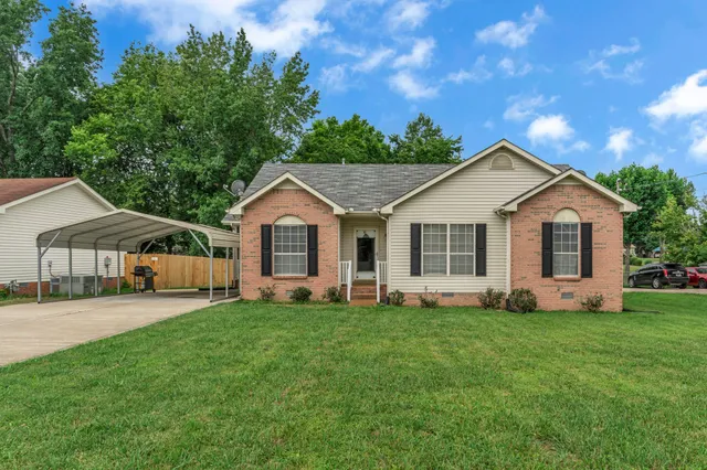a front view of a house with a yard and trees