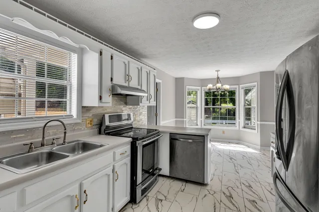 a kitchen that has a sink cabinets counter space and stainless steel appliances