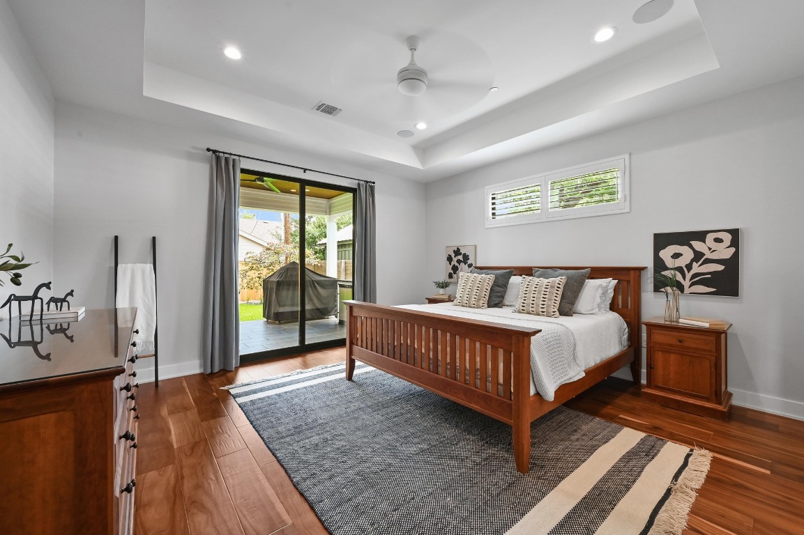 3102 Hunt Trail Austin, TX 78757 - Photo 16 of 38 Primary BD on main floor with access to outside, multiple windows, dark wood-style flooring, and recessed lighting