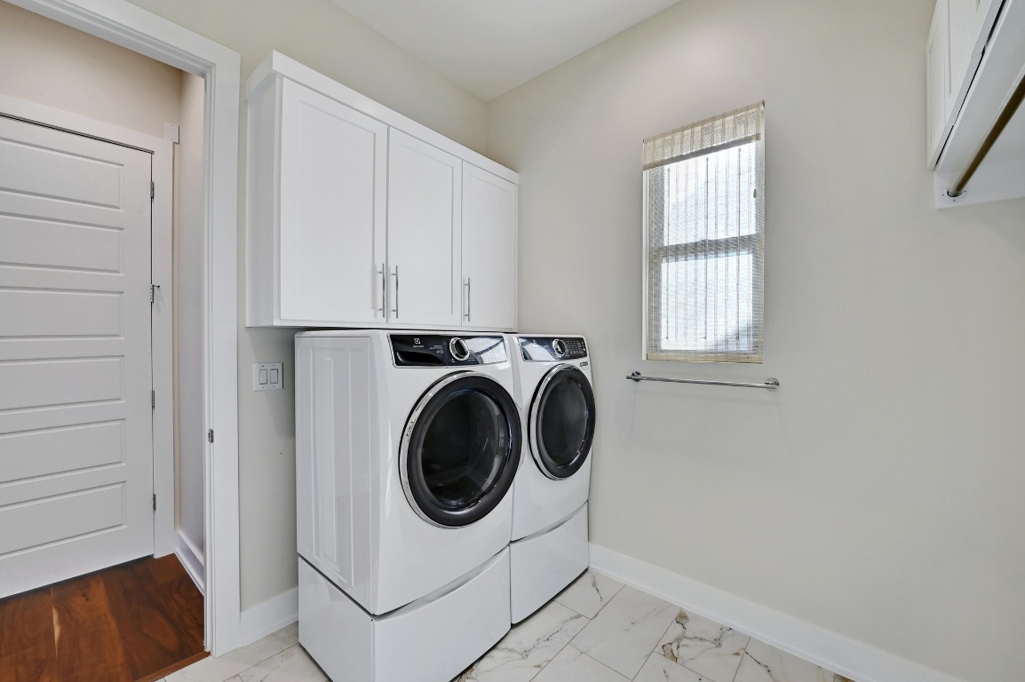 3102 Hunt Trail Austin, TX 78757 - Photo 29 of 38 Washroom with light marble finish flooring, cabinet space, and washer and dryer