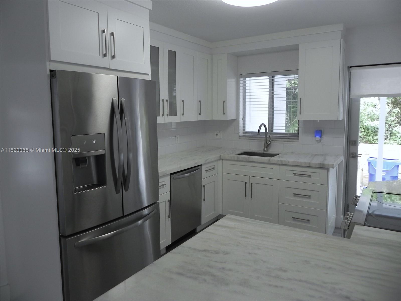 Bayside Miami, FL 33138 - Photo 13 of 44 a kitchen with white cabinets and stainless steel appliances