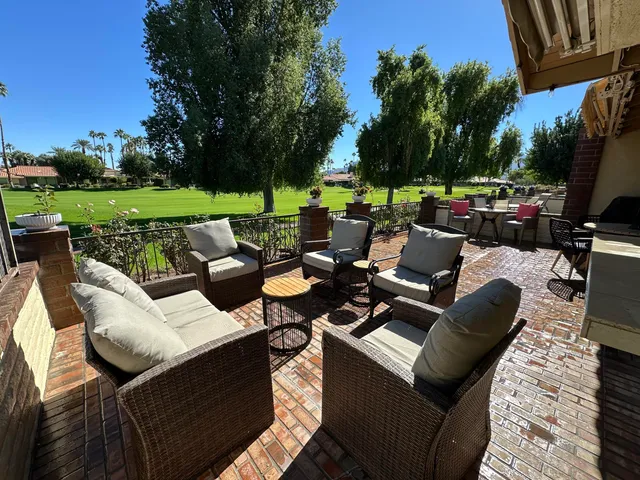 a view of a patio with couches chairs and a yard