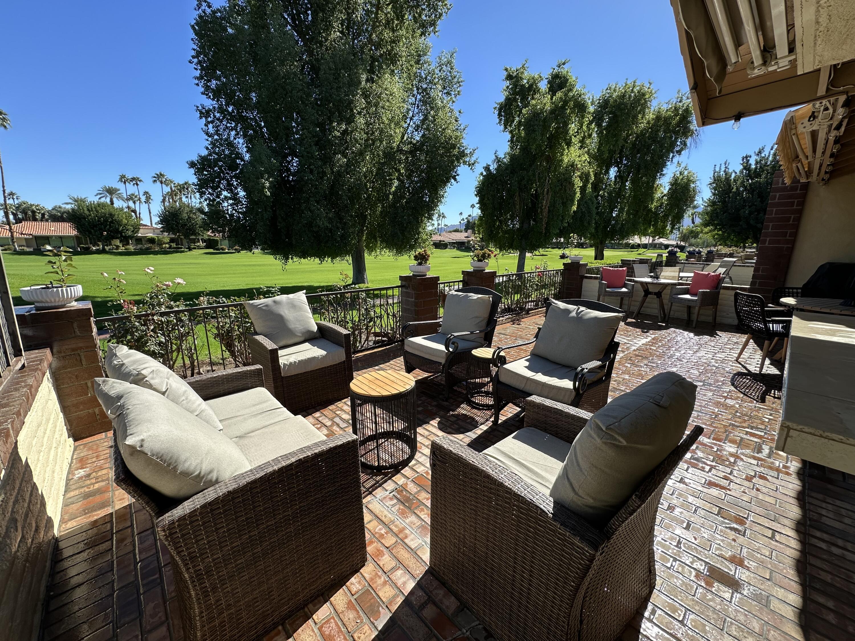 a view of a patio with couches chairs and a yard