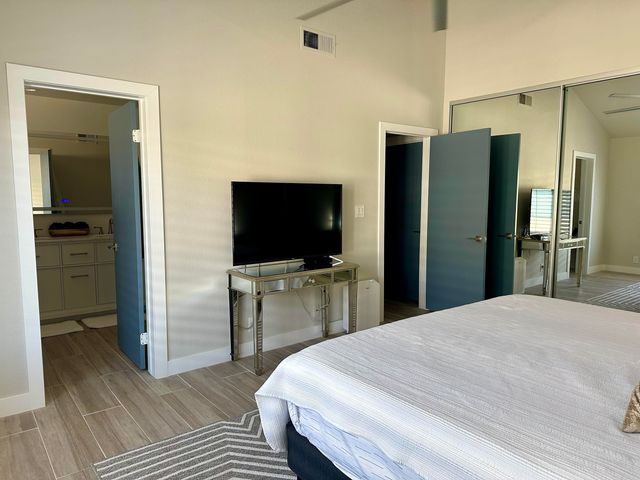 a large bedroom with a bed and a flat screen tv