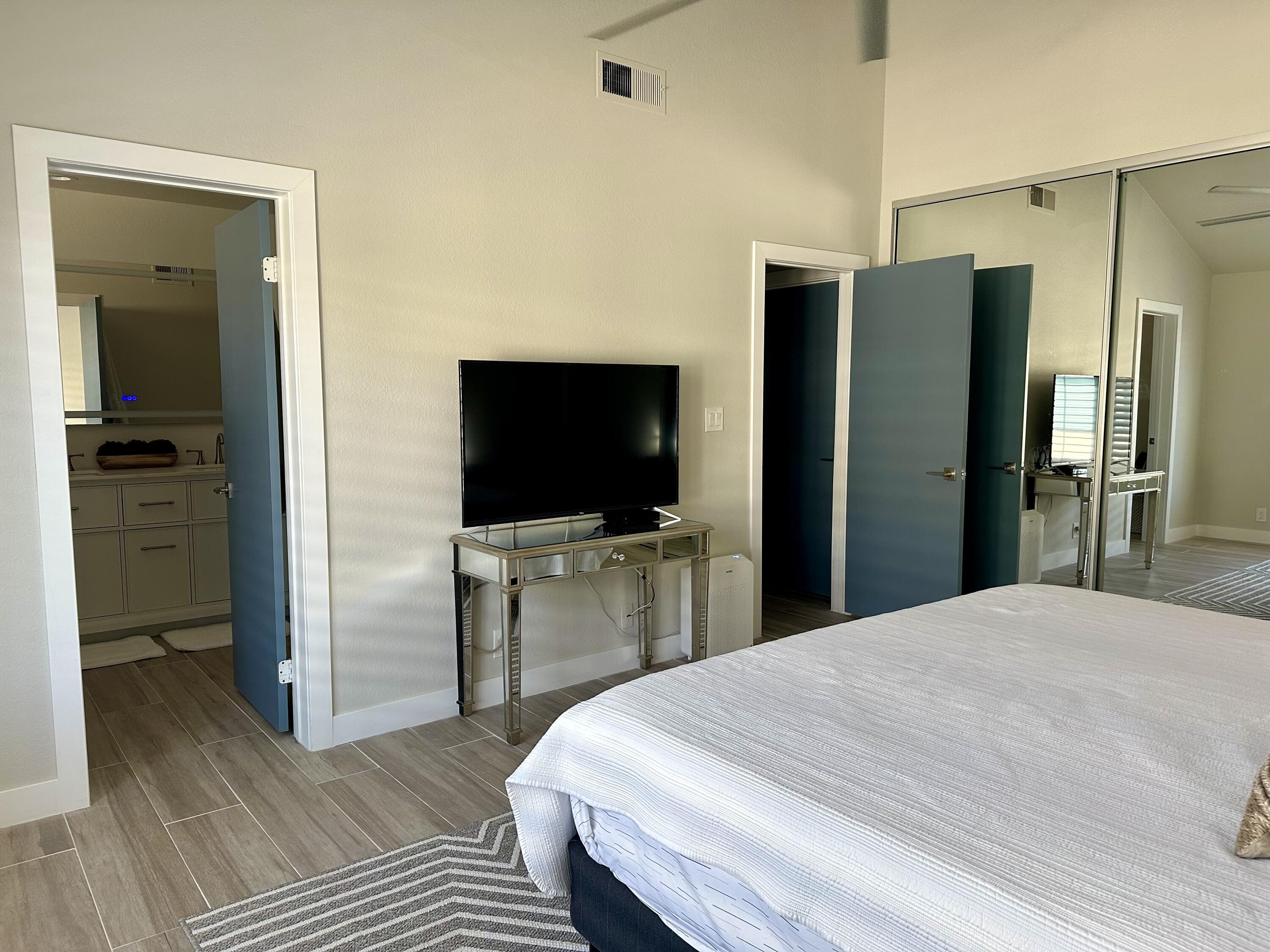 246 Santa Barbara Circle Palm Desert, CA 92260 - Photo 11 of 16 a large bedroom with a bed and a flat screen tv