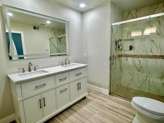 a bathroom with a granite countertop sink toilet and shower