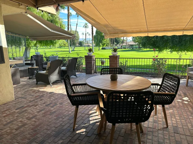 a view of a patio with a table chairs and a backyard