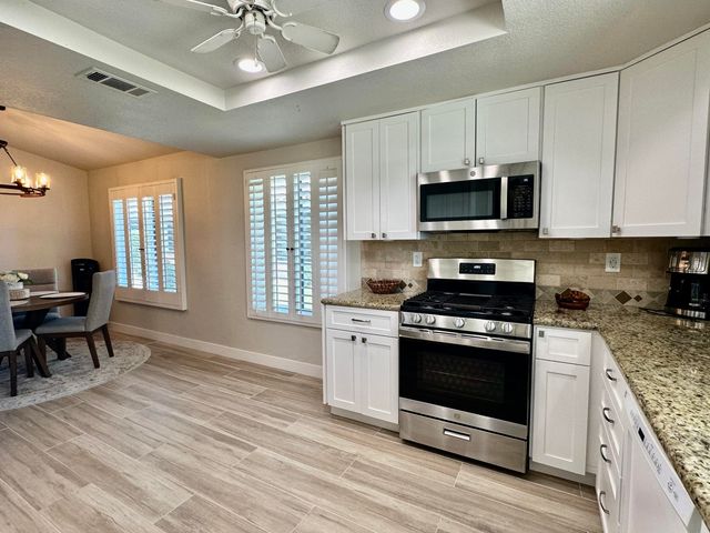 a kitchen with stainless steel appliances granite countertop a stove and a microwave