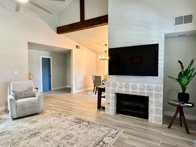 a living room with furniture a fireplace and a flat screen tv