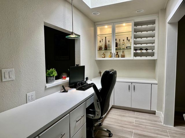 a view of a workspace with furniture and a window