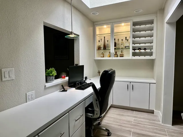 a view of a workspace with furniture and a window