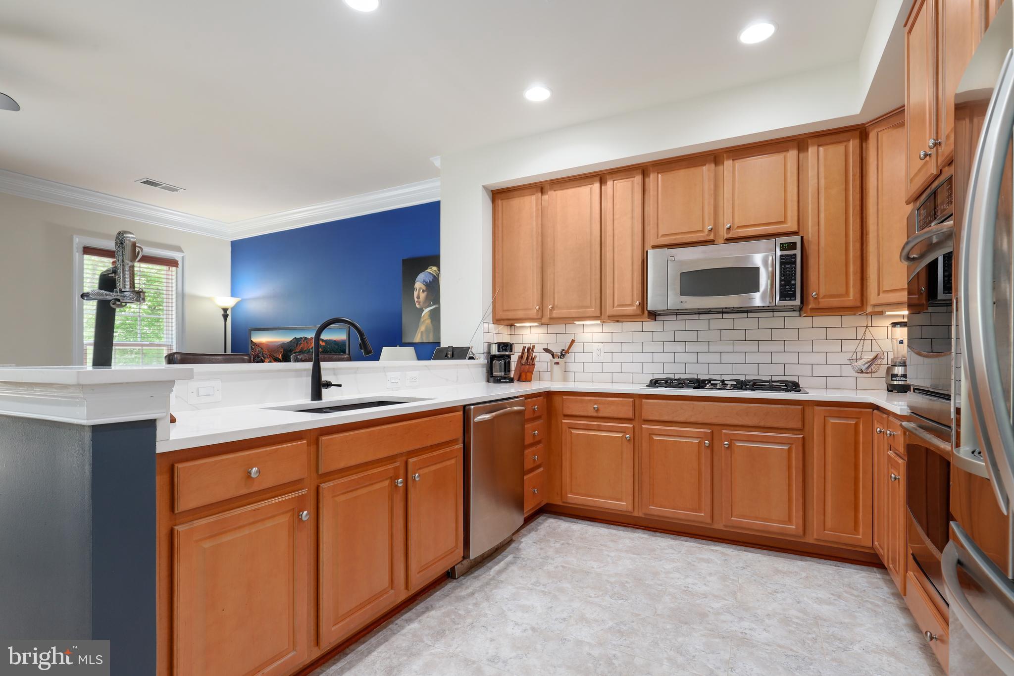44268 Panther Ridge Drive Ashburn, VA 20147 - Photo 17 of 32 a kitchen with stainless steel appliances granite countertop a sink stove and cabinets