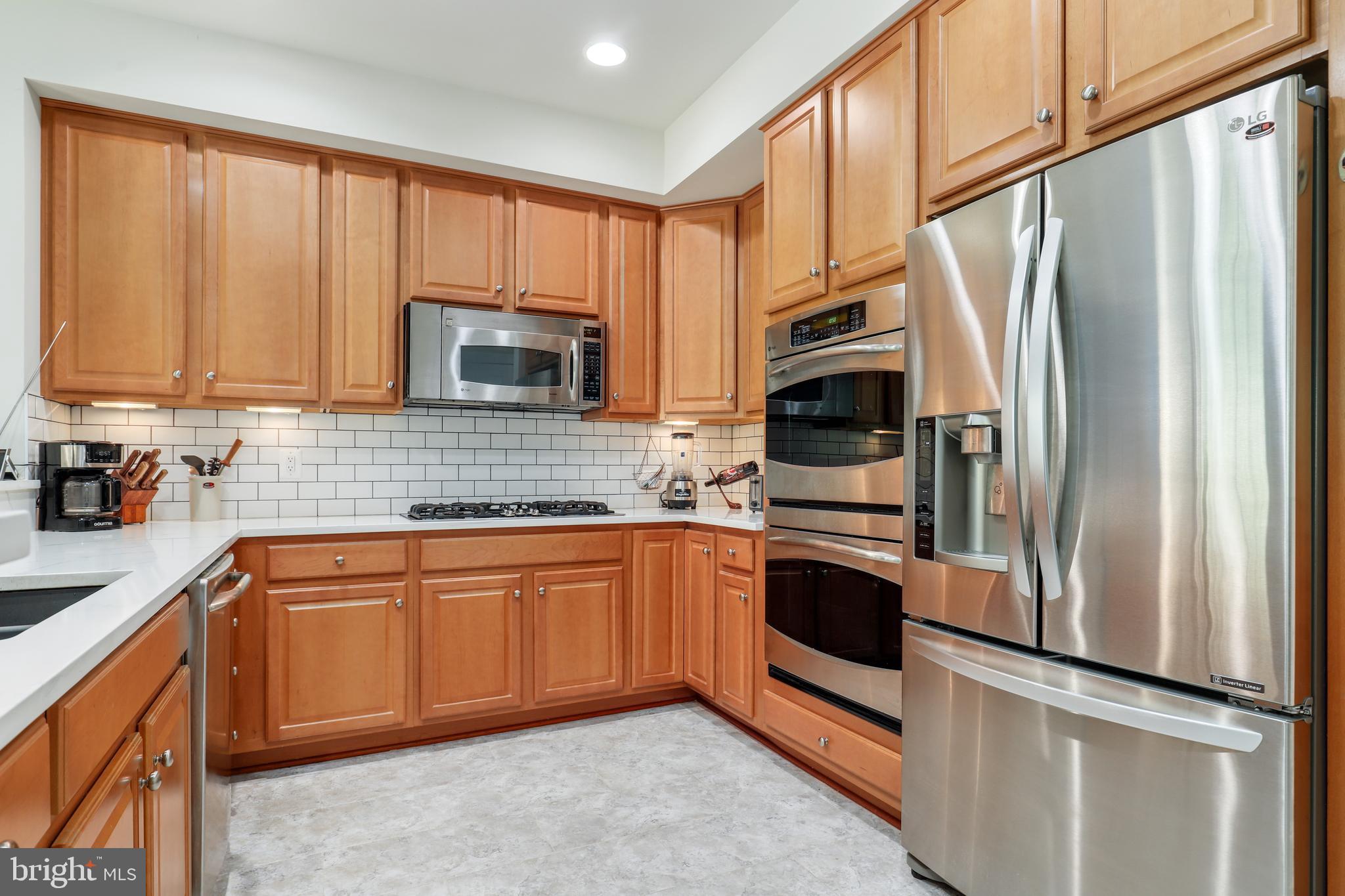 44268 Panther Ridge Drive Ashburn, VA 20147 - Photo 18 of 32 a kitchen with stainless steel appliances granite countertop a refrigerator stove top oven and sink