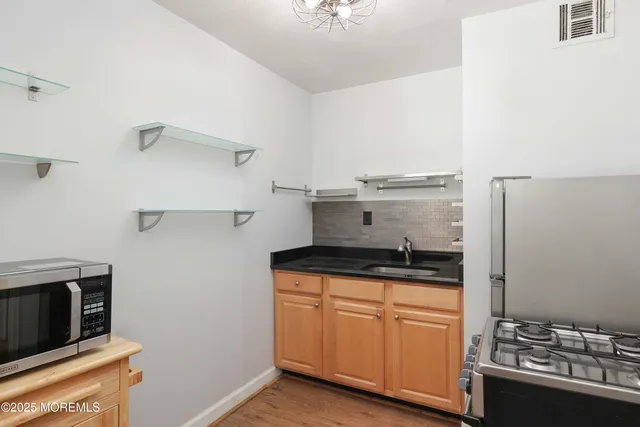 a kitchen with stainless steel appliances granite countertop a stove and a refrigerator