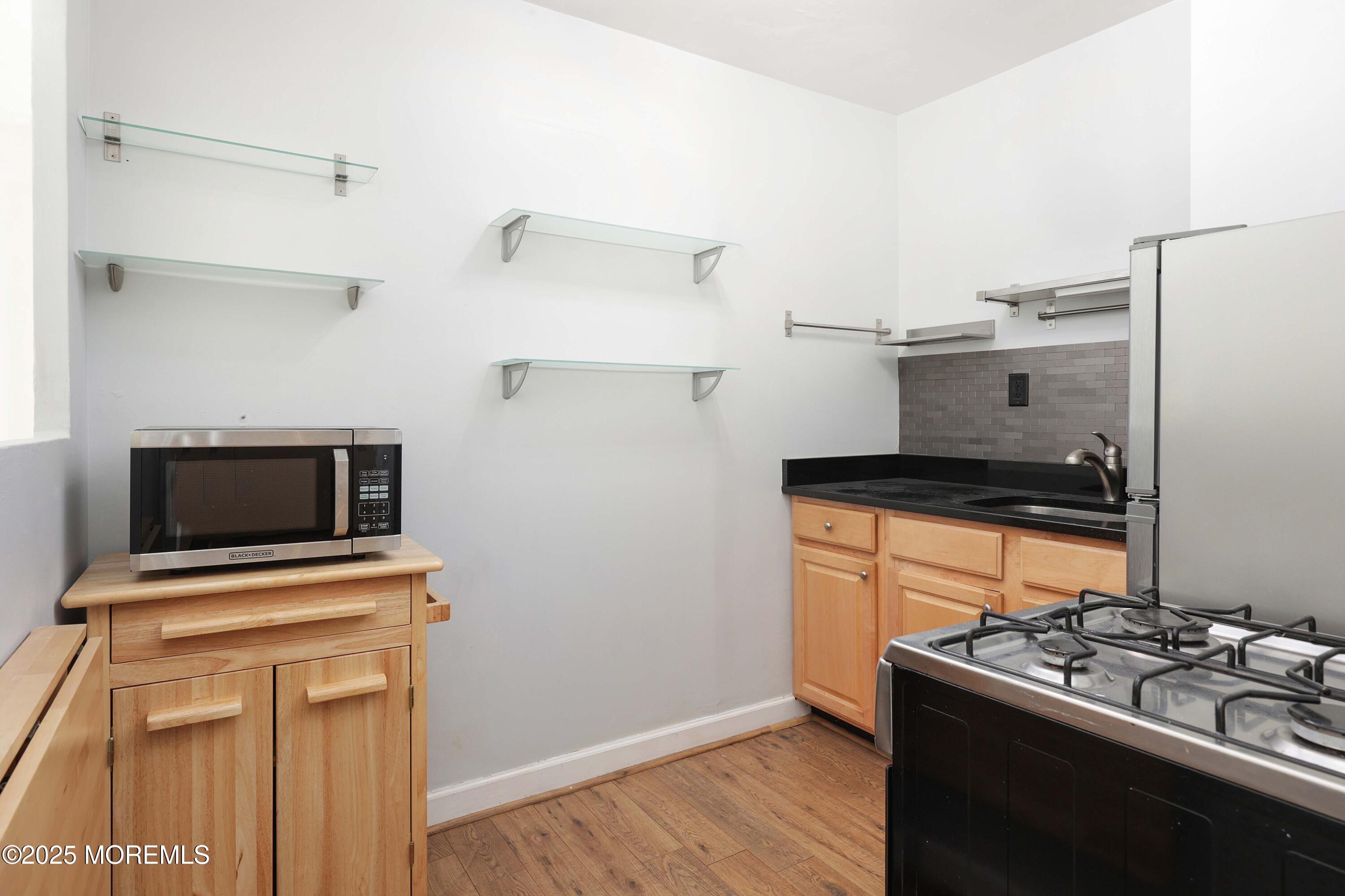 28 Riverside Avenue, Unit 7D Red Bank, NJ 07701 - Photo 9 of 28 a kitchen with a stove and a microwave
