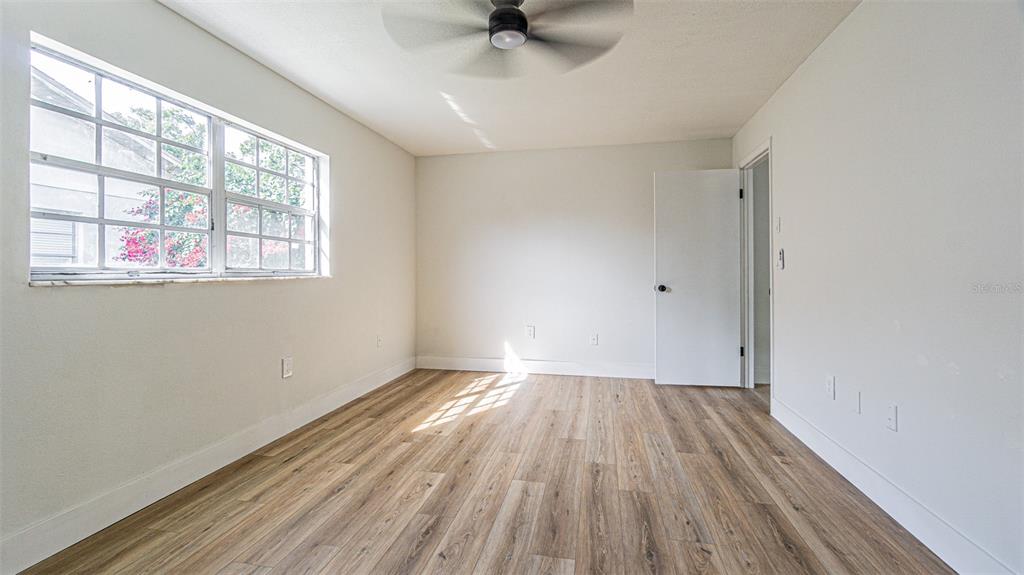 8405 Reynolds Drive Hudson, FL 34667 - Photo 12 of 30 a view of an empty room with a window and wooden floor