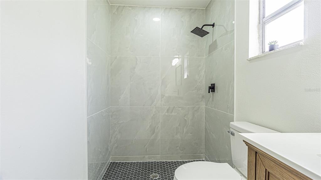 8405 Reynolds Drive Hudson, FL 34667 - Photo 14 of 30 a bathroom with a shower a toilet and a sink