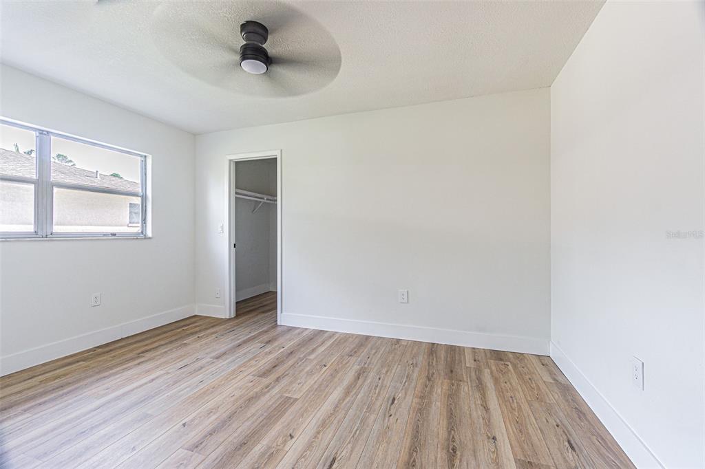 8405 Reynolds Drive Hudson, FL 34667 - Photo 18 of 30 an empty room with a hardwood and ceiling fan
