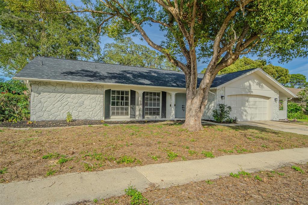 8405 Reynolds Drive Hudson, FL 34667 - Photo 2 of 30 a front view of a house with a garden and tree