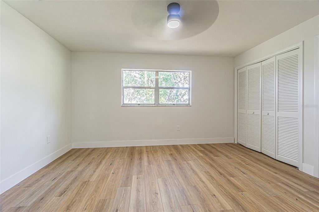 8405 Reynolds Drive Hudson, FL 34667 - Photo 21 of 30 an empty room with wooden floor and windows