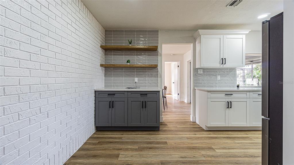 8405 Reynolds Drive Hudson, FL 34667 - Photo 9 of 30 a kitchen with stainless steel appliances wooden floor and more cabinets