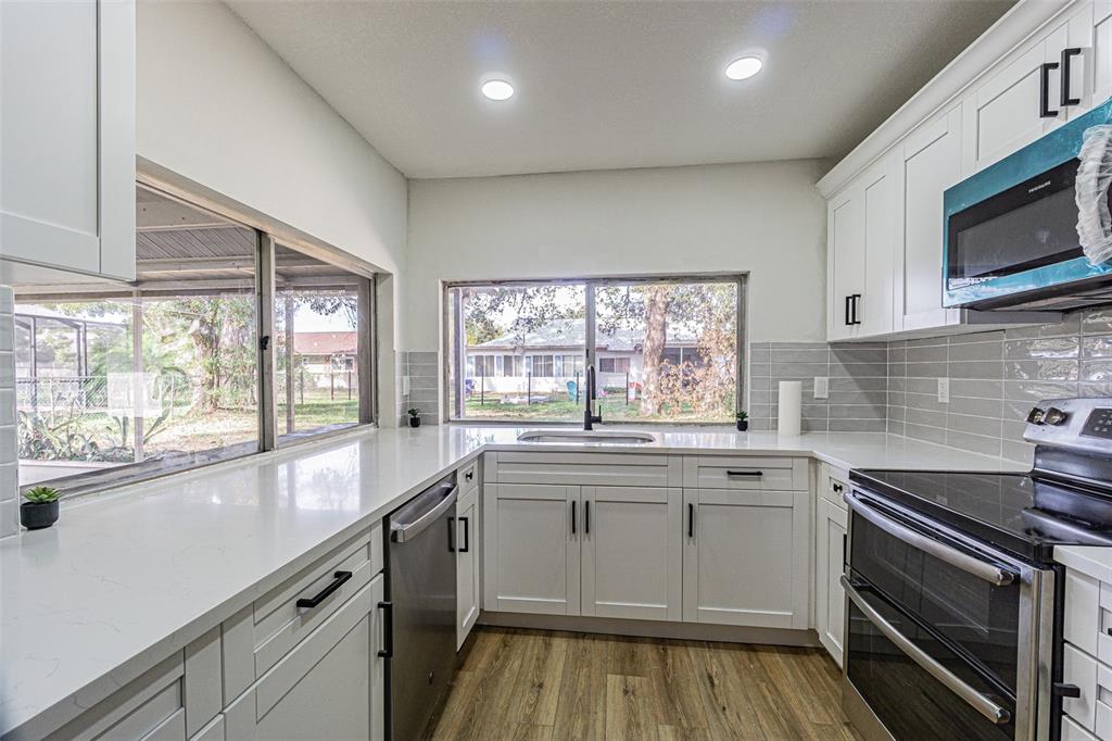 8405 Reynolds Drive Hudson, FL 34667 - Photo 10 of 30 a kitchen with stainless steel appliances a stove sink and microwave